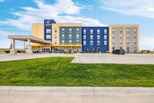 Un hotel Comfort Inn & Suites con entrada cubierta, varios pisos y estacionamiento.