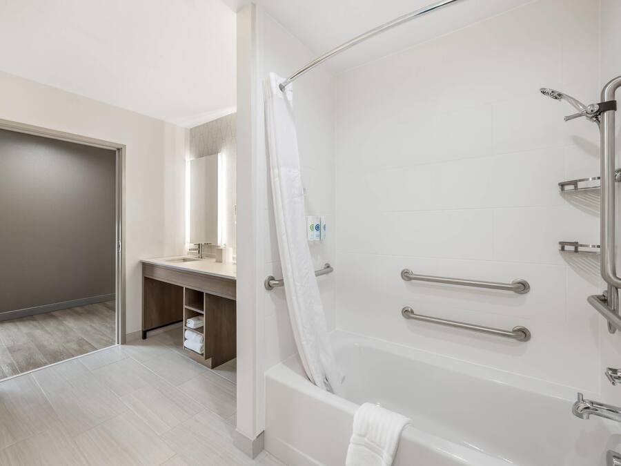 A modern bathroom with a bathtub, shower, and vanity.