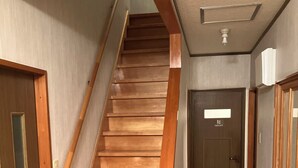 A wooden staircase leading to a door labeled "TOILET".