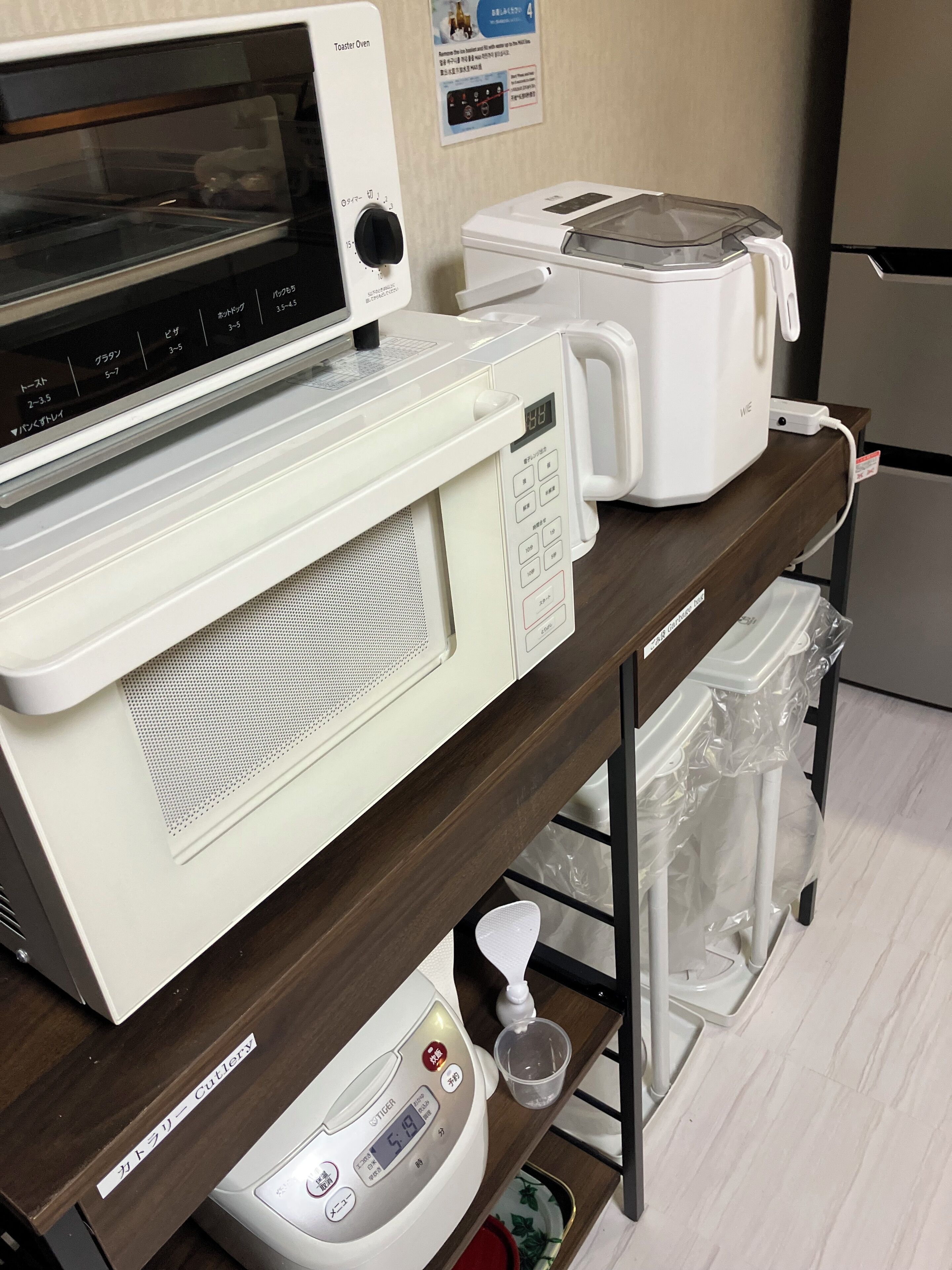 A kitchen area with a microwave, toaster, and a digital scale.