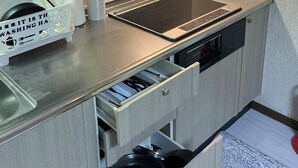 A modern kitchen with a built-in stovetop, a window, and a black range hood.