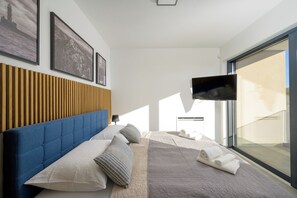 Relax in a spacious room with a large bed, flat-screen TV, and a window offering a view of the outside.