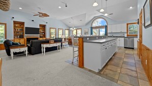 Amplia sala de estar con chimenea, comedor y cocina con una isla grande.