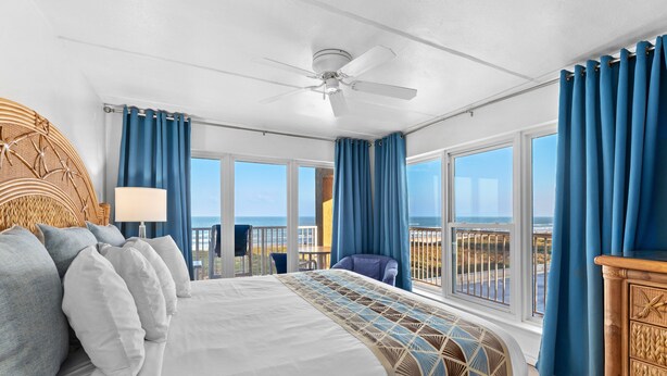 A bedroom with a large bed, a ceiling fan, and a view of the ocean. - Experience Beachfront Luxury w/ Spectacular Views! Pool & Hot Tub (South Padre Island)