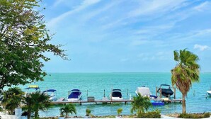A marina with boats docked, a wooden pier, and palm trees. - Studio - Lagoon-View Balcony - Cancun Hotel Zone (Cancún)