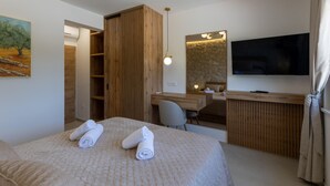 A hotel room with a bed, a desk, a chair, a TV, and a painting on the wall. - Amazing home in Slivno Ravno with sauna (Slivno Ravno)