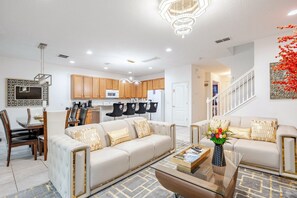 A modern living room with a sofa, coffee table, and dining area.