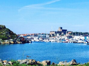 A coastal town with a marina, rocky shoreline, and a prominent building with a tower. - 5 Star Holiday Home in Marstrand (Marstrand)