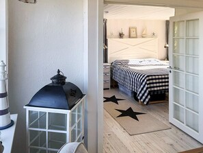 A bedroom with a bed, a nightstand, a lamp, and a star-patterned rug. - 5 Star Holiday Home in Marstrand (Marstrand)
