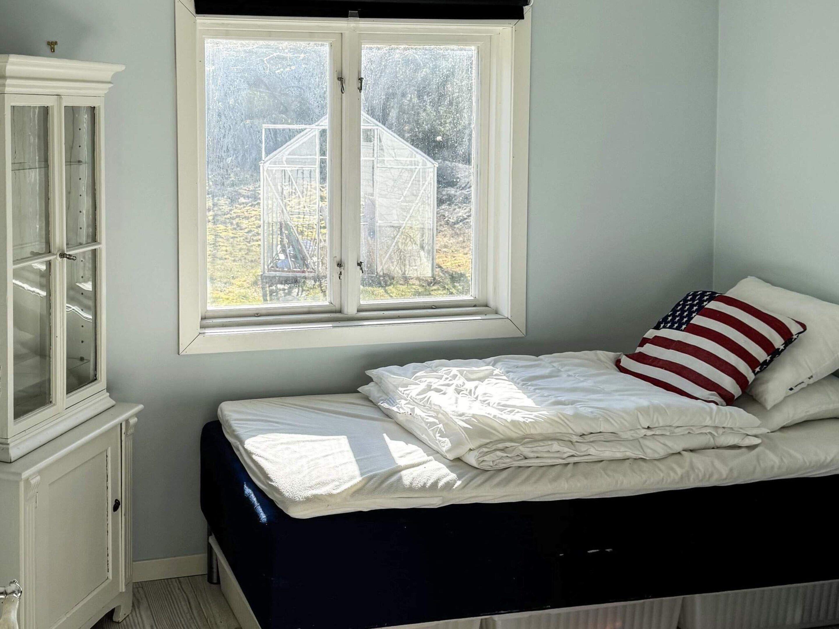 Une chambre à coucher avec un lit, une fenêtre et une armoire.