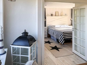 A bedroom with a bed, a nightstand, a lamp, and a star-patterned rug.