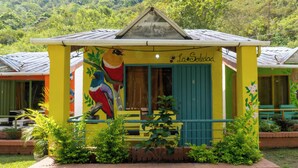 A colorful building with a mural of a bird, a sign reading "La Soledad," and a green door.