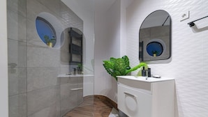 A modern bathroom with a vanity, a large mirror, and a potted plant. - Central Square Haven B (București)
