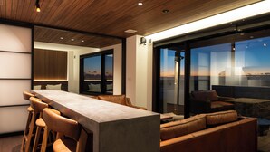 Ein modernes Interieur mit Bar, Sitzgelegenheiten und großen Fenstern mit Blick.