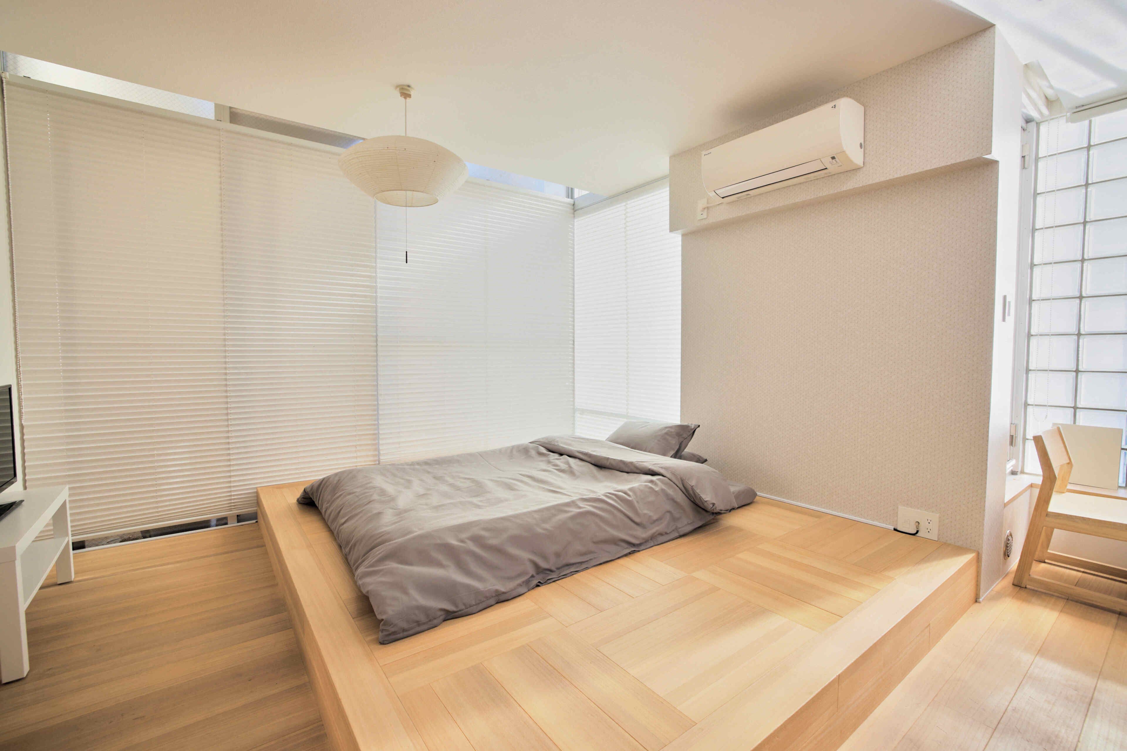 A modern bedroom with a built-in bed, a desk, and a chair.