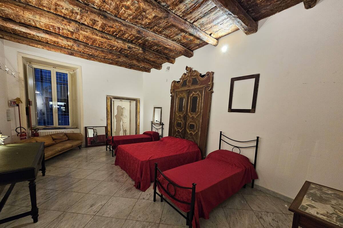 Una habitación con dos camas, un sofá, una mesa y un espejo.