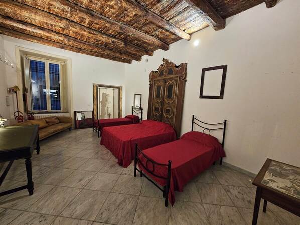 A room with two beds, a sofa, a table, and a mirror. - The Spanish Palace suites, rooms, apartments & terraces (Naples)