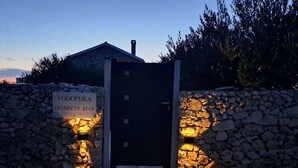 A stone wall entrance with a sign reading "VODOPIJKA OSTARICEV STAN". - Villa Maslina: Rustic villa in an olive grove facing a bird sanctuary  (Kolan)