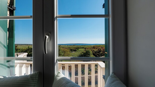 A room with a view of a landscape through a window. - Villa Maslina: Rustic villa in an olive grove facing a bird sanctuary  (Kolan)