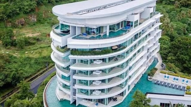 Un hotel a più piani con piscina a livello strada.