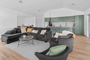 Relax in this stylish living room with a comfortable sofa and kitchen area.