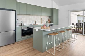 Enjoy cooking in this kitchen with a sleek refrigerator, oven, and sink.