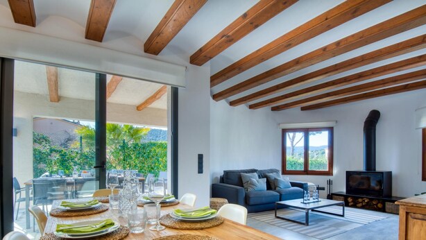 A spacious living area with a dining table set for four, a sofa, and a fireplace.