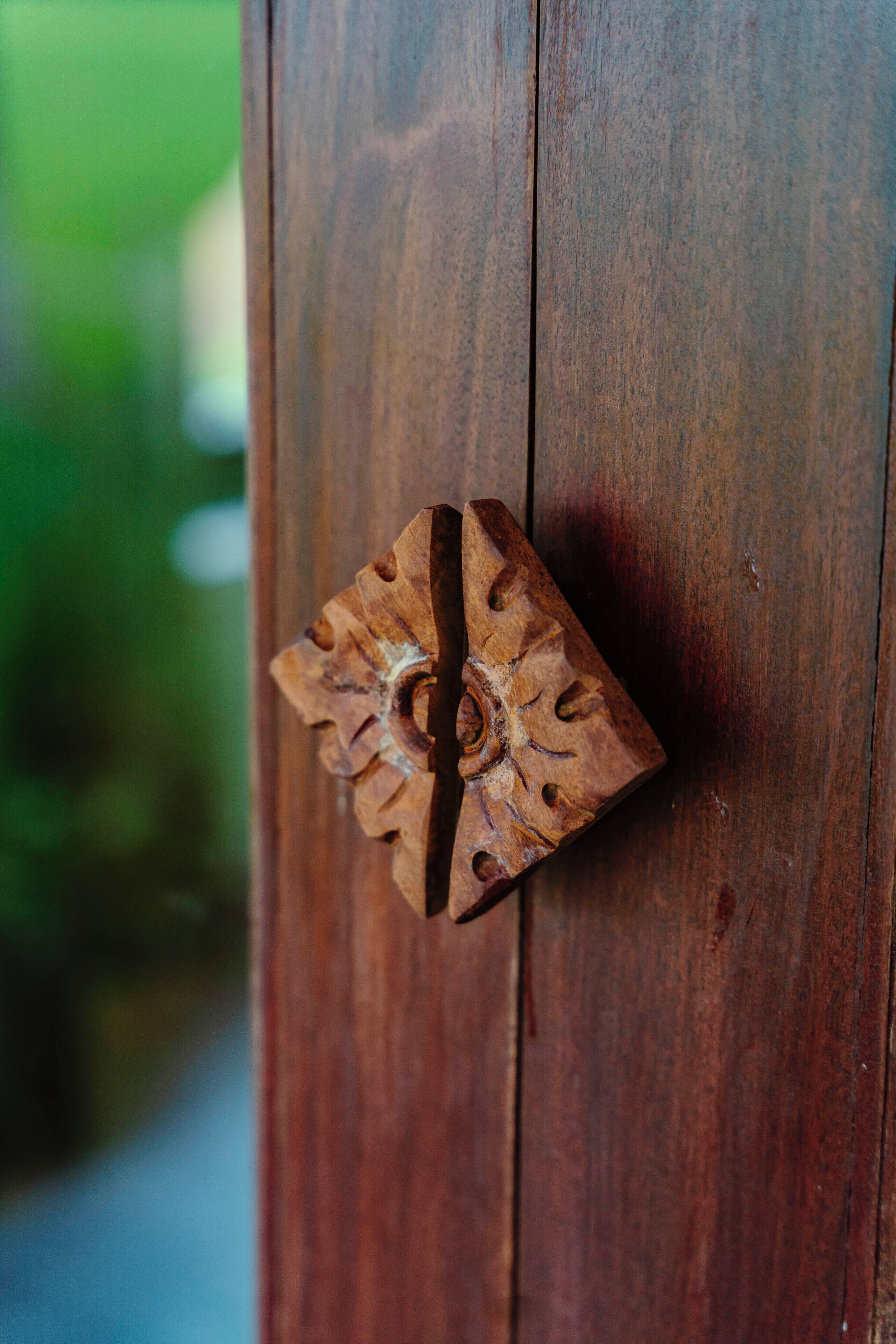 A wooden door with a decorative metal handle.