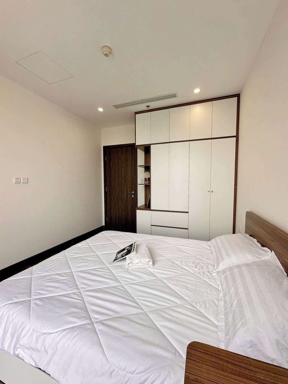 A bedroom with a bed, a wardrobe, a mirror, and a ceiling light.