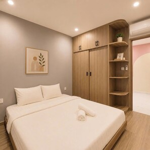 A bedroom with a bed, wooden wardrobe, and a wall-mounted shelf with a plant. - Lyshing Apartment in Vinhomes Grand Park (Ho Chi Minh City)