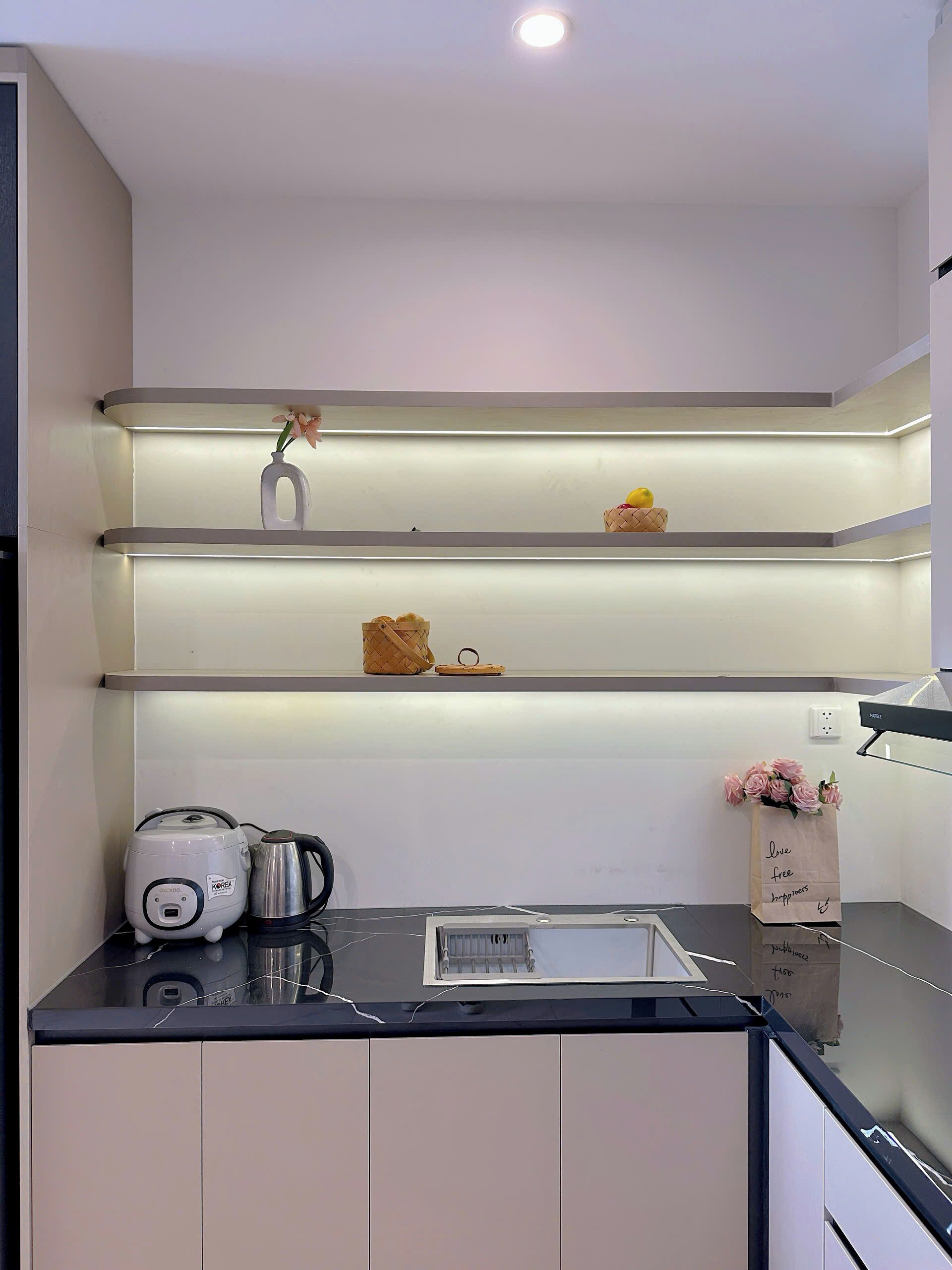 Una cucina moderna con scaffali a incasso, un bollitore e una macchina da caffè.