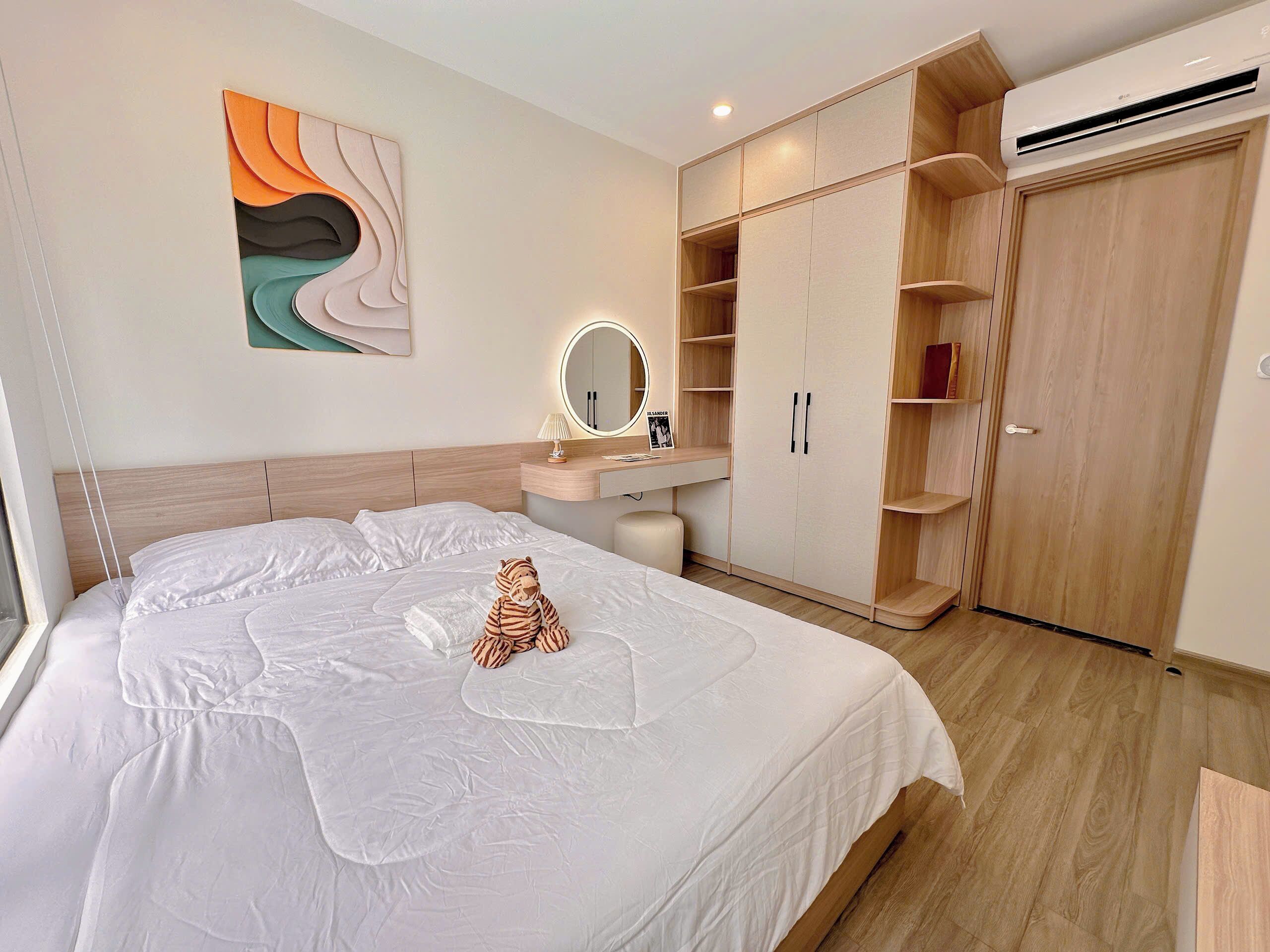 Una camera da letto con un letto, un comodino con una lampada, uno specchio, un armadio e un quadro appeso al muro.