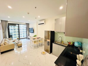 Apartamento família, sacada, vista para a cidade | Área de estar | TV de tela plana