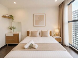 A modern hotel room with a large bed, a bedside table with a lamp, a window with curtains, and a wall-mounted picture. - Lyshing Apartment in Vinhomes Grand Park (Ho Chi Minh City)