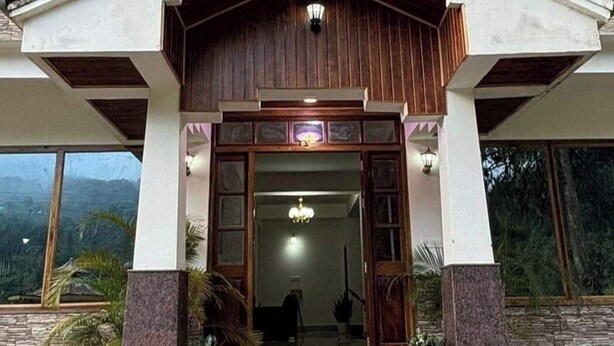 Un edificio con facciata in legno, ampie finestre e un balcone.