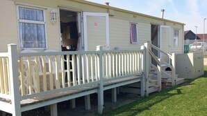 A mobile home with a deck, a staircase, and a door open to a room. - 3Bed-Sleeps6-Pet Friendly-FamilyFriendly (Mablethorpe)
