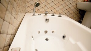 Une baignoire dotée d’un panneau de commande et de plusieurs robinets.