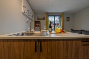 A kitchen with a large island, a sink, and a dining area with a table and chairs.