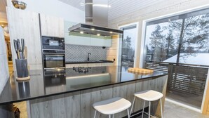 Una cucina moderna con un'isola grande, elettrodomestici in acciaio inossidabile e vista sull'esterno.
