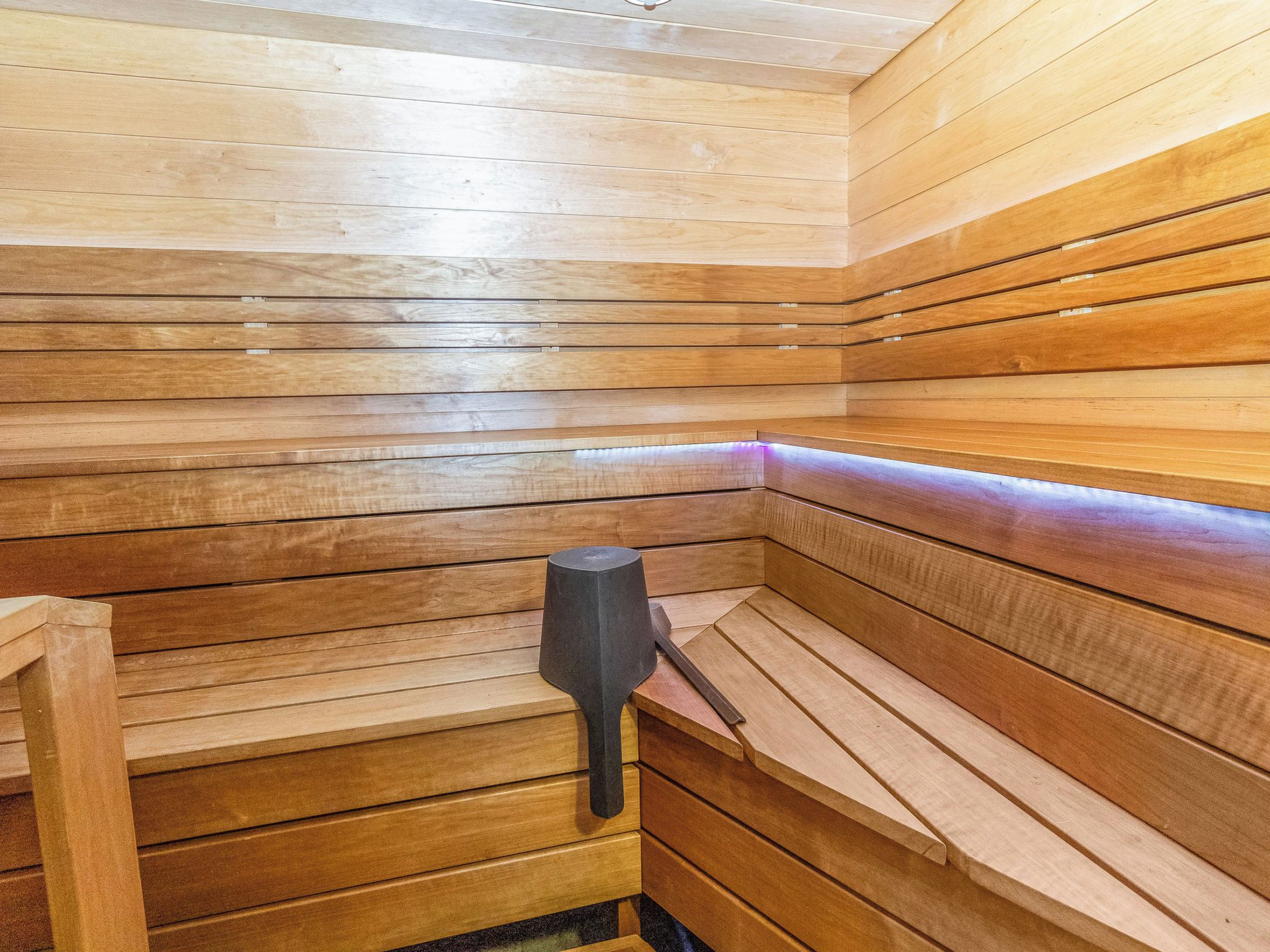 Eine Sauna mit Holzbänken und einem zentralen Heizaggregat.