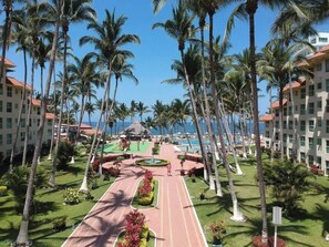 Ein Resort mit einem zentralen Weg, Palmen und Blick auf den Ozean.