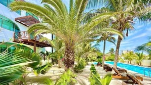 A resort with a pool, palm trees, and a building with a balcony. - Villa · Private Pool · Ocean View · Isla Mujeres (Isla Mujeres)