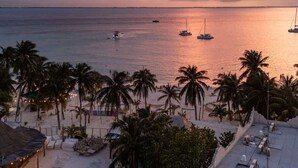 A beach view with palm trees, boats, and a sunset. - Villa · Private Pool · Ocean View · Isla Mujeres (Isla Mujeres)