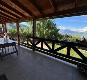 Enjoy a serene mountain view from this outdoor space with a dining table and chairs.