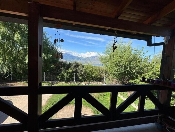 Relax in a serene outdoor space with a breathtaking view of the surrounding mountains and tranquil body of water.