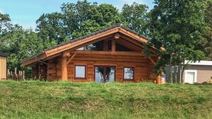 A log cabin with a pitched roof, two front doors, and a small window on each side. - 3 bedroom lovely home in Den Oever (Den Oever)