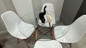 A round glass table with four white chairs. - Entire guest suite in Calgary (Calgary)