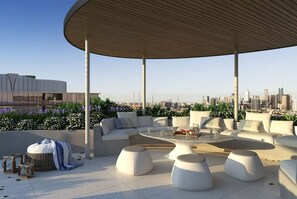 Relax and unwind on this rooftop terrace with a city view, featuring a semi-circular canopy and comfortable seating.