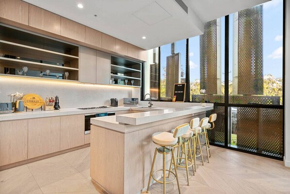 Enjoy cooking in this well-equipped kitchen with a central island, sink, and bar area.