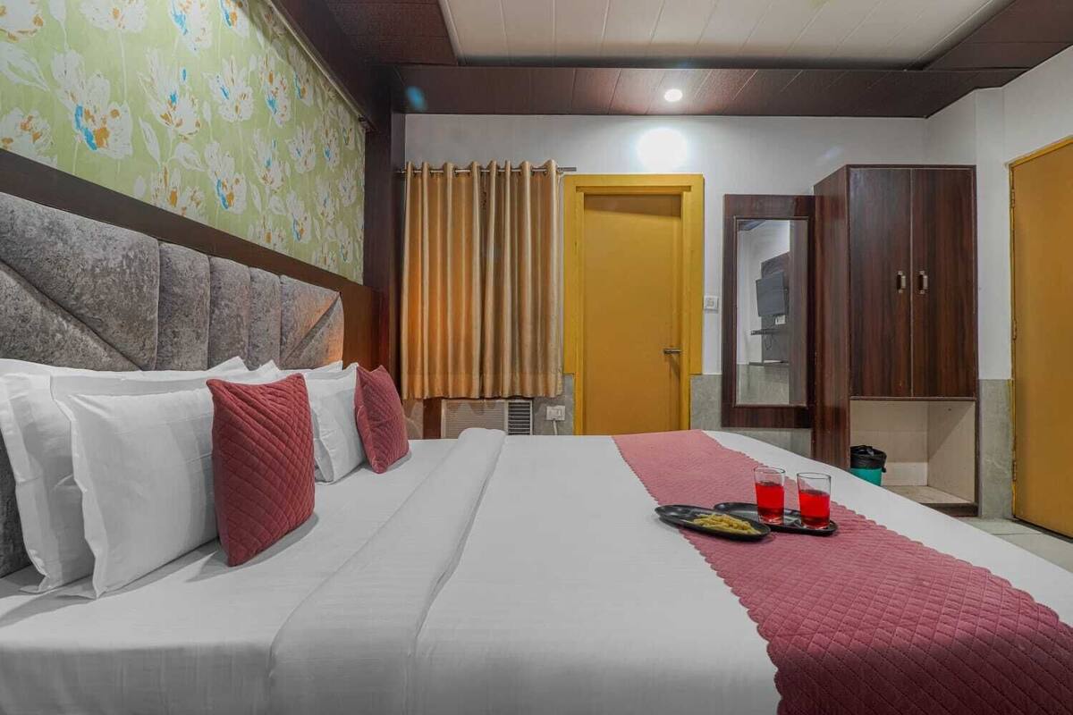 Ein Hotelzimmer mit Bett, Schrank, Spiegel und Tür.